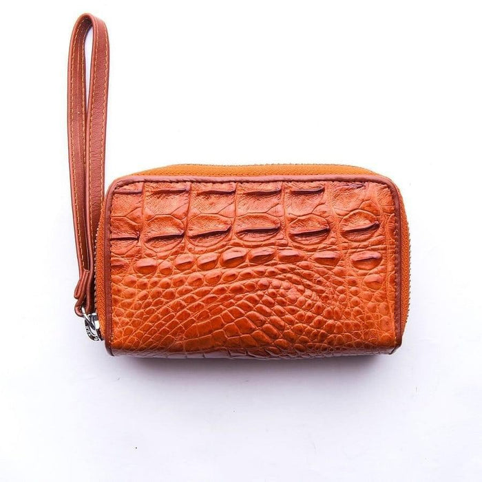 Light brown genuine crocodile skin zip wallet with textured scales and matching leather wrist strap against white background