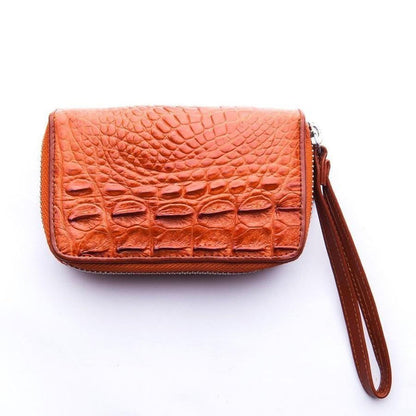 Rear panel of pocket-sized brown crocodile leather wallet featuring raised hornback scale pattern and wrist strap