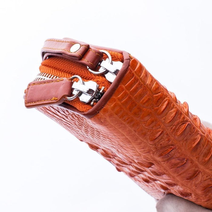 Close-up detail of durable zipper hardware on the crocodile leather wallet