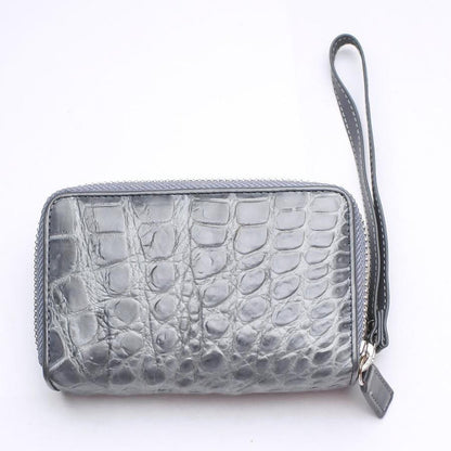 Front face of handcrafted gray crocodile wallet displaying smooth belly scale pattern with zip-around closure and wrist loop