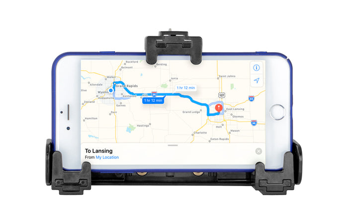 A smartphone in a black LockVise™ Universal Locking Phone Holder with Key Lock displays a navigation map showing a blue route from Grand Rapids to Lansing, with an estimated travel time of 1 hour and 12 minutes.