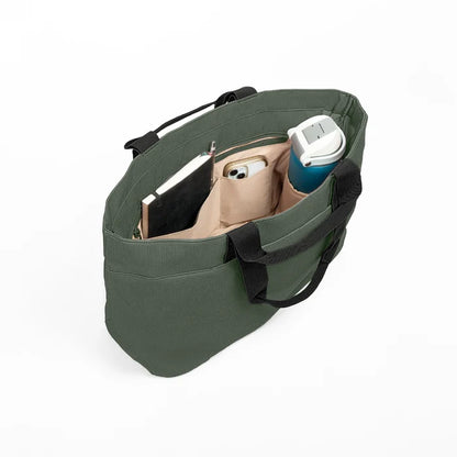 Luxe Tote bag, the olive green canvas tote bag shown from an overhead angle, filled with a notebook, a smartphone, and a blue water bottle, on a clean white background.