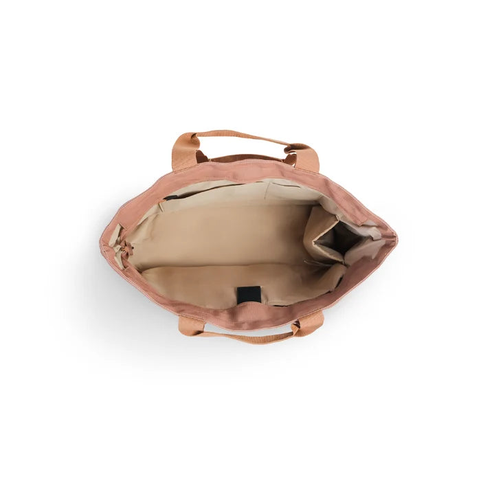Luxe tote bag An overhead view of a dusty rose canvas tote bag showing its beige interior lining and top handles against a white background.