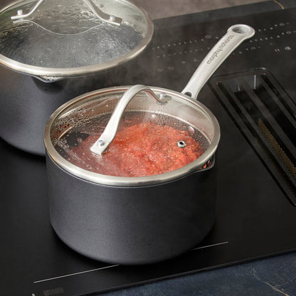 Saucepan with tomato sauce with lid on, on induction hob