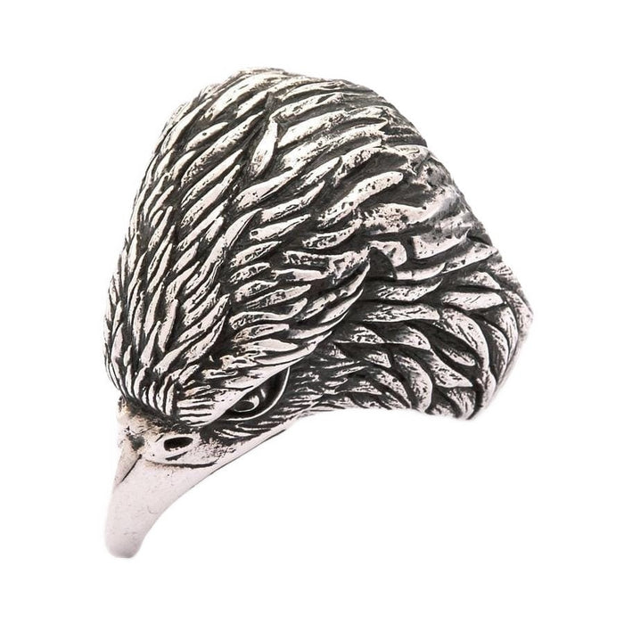 Left profile view of oxidized silver eagle ring with dramatic shadowing between hand-carved feathers