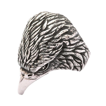 Left profile view of oxidized silver eagle ring with dramatic shadowing between hand-carved feathers
