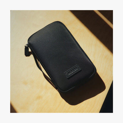 Carbon Black | Angle view of Metro Travel Wallet in Carbon Black on a wooden table