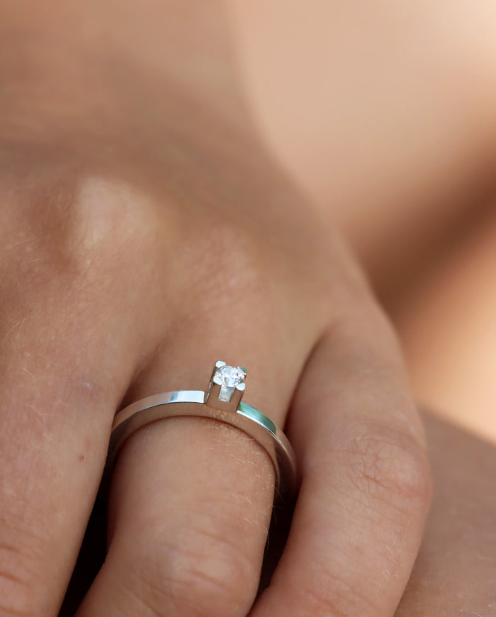 Tjej som bär en Vigsel eller Förlovningsring i silver med 0,10 ct diamant i fyrkantig fattning.