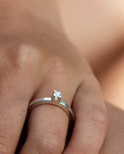 Tjej som bär en Vigsel eller Förlovningsring i silver med 0,10 ct diamant i fyrkantig fattning.