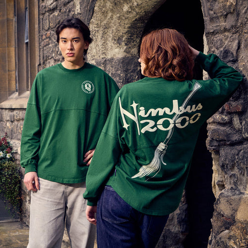 Two people wearing Nimbus 2000 Spirit Jerseys in front of a stone building.
