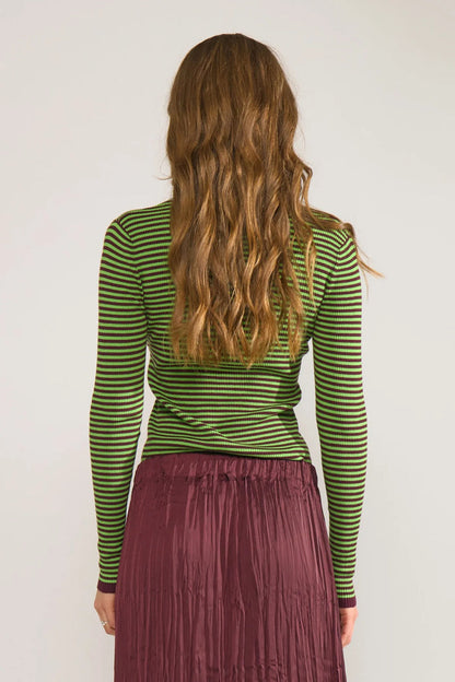 Back view of a model wearing Numph 706923 NUFILINA Pullover – Fig striped in green and dark tones, paired with a textured burgundy skirt by Numph. Shop Numph at Dotique.