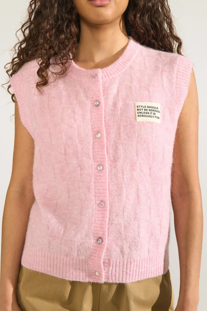 Model wearing Numph 706928 NURIETTE CHECK VEST – Pink Lady sleeveless knitted vest with button front and patch detail by Numph. Shop Numph at Dotique.