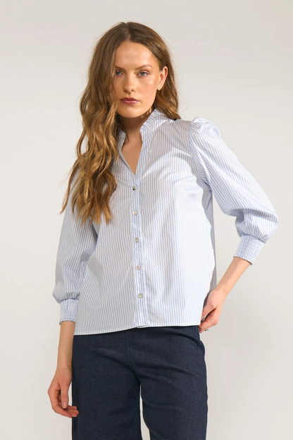 Model wearing Numph 707070 Nulili Blouse Floaty Blue with vertical stripes and button front, styled with dark trousers by Numph. Shop Numph at Dotique.
