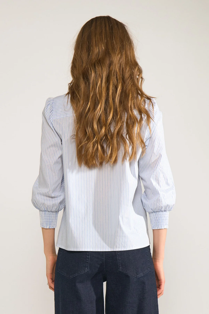 Back view of model wearing Numph 707070 Nulili Blouse Floaty Blue with subtle stripes and puffed sleeves by Numph. Shop Numph at Dotique.
