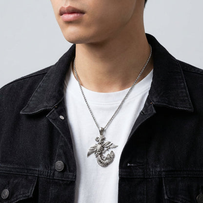 Man wearing a sterling silver phoenix pendant necklace with intricate feather details on a chain, styled with a white t-shirt and black denim jacket