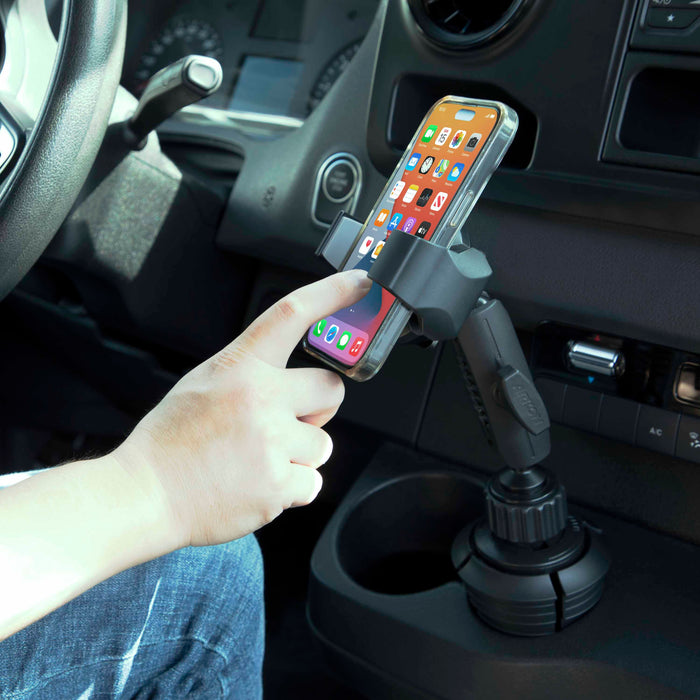 A hand touches a smartphone held in the RoadVise® Ultra Holder with Cup Holder Mount; the lit home screen and apps show how it keeps your car dashboard tidy while enabling convenient hands-free calling on the road.