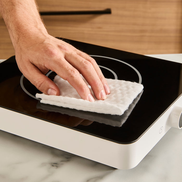 hand wiping single induction cooker with cloth