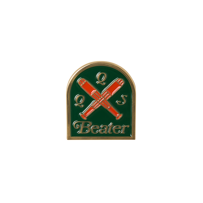 Pin with crossed red beater sticks on a green background