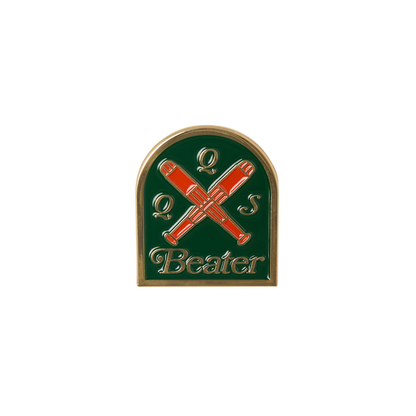Pin with crossed red beater sticks on a green background