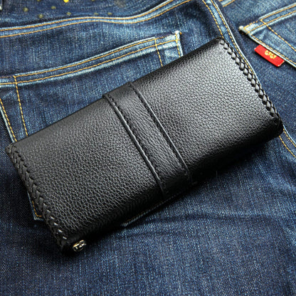 Vertical strap runs down the pebbled back, braided stitching at the edges and a chain loop at the corner.