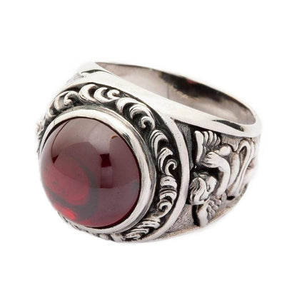 An angled view of the men's gothic red stone ring with cupid engravings.