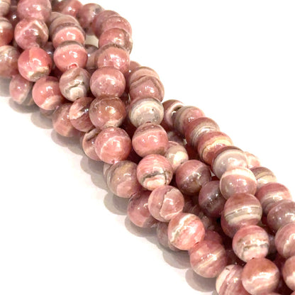6mm Rhodochrosite smooth round gemstone strand on a white background, front overview.