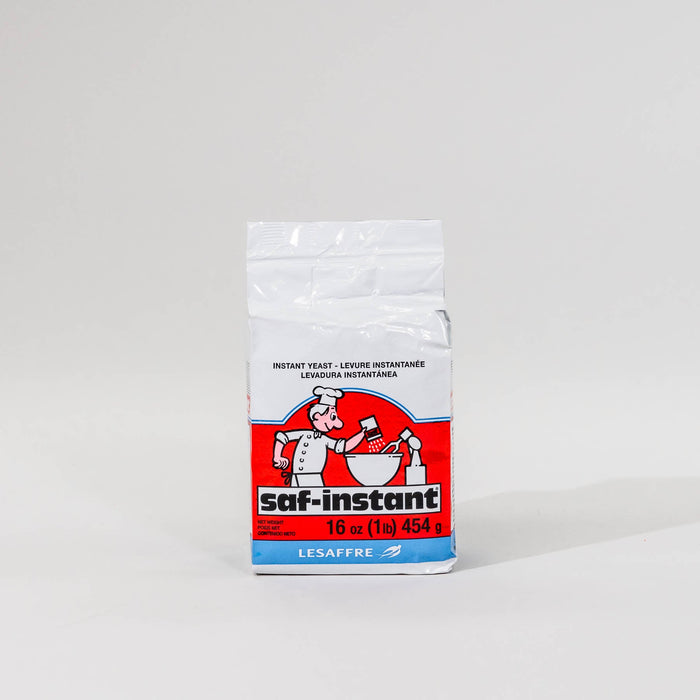 A single package of Saf Instant yeast on a grey background
