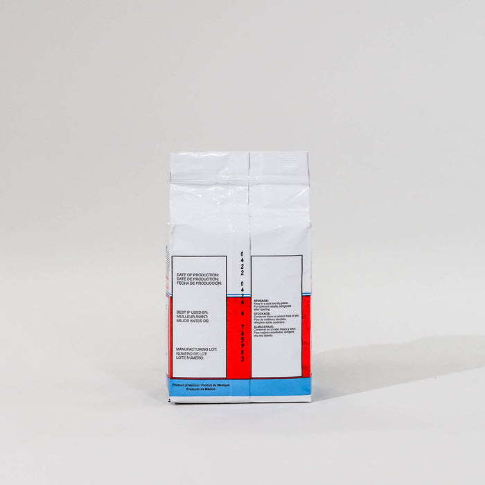 Back view of a single package of Saf Instant yeast on a grey background