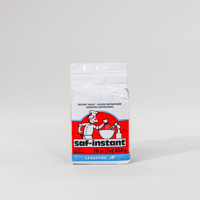 A package of SAF Red Label Instant Yeast with a predominantly white label featuring a red logo and a picture of a chef.