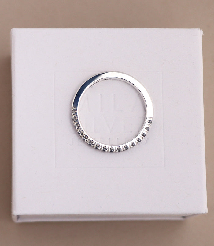 diamantring sedd uppifrån där man ser diamanternas infattning i kronor. Ringen är en silverring med raka kanter, halva ringen är infattad med diamanter.