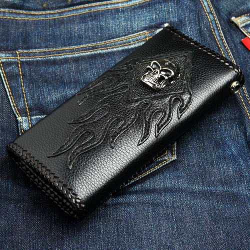 Skull stingray chain wallet lying on denim — flame appliqué cover, braided edge, polished skull on the diamond inlay
