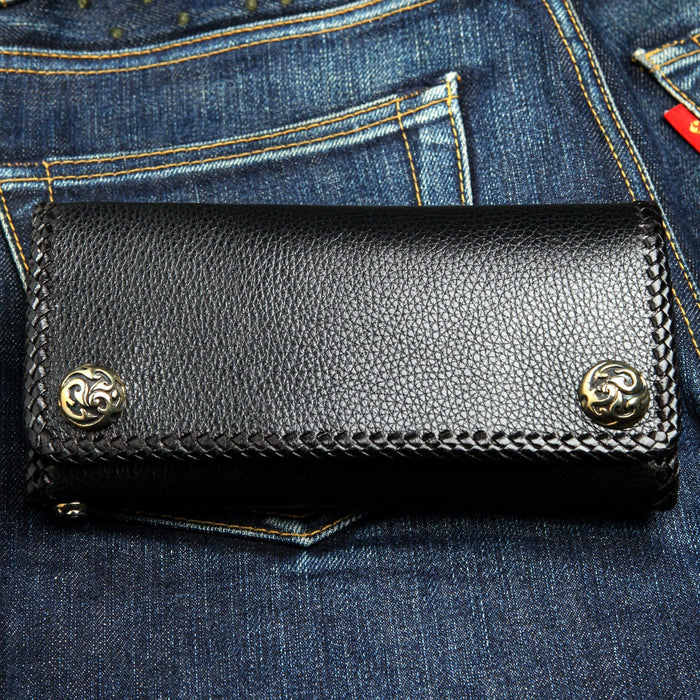 Back of the biker chain wallet: pebbled black cowhide, hand-braided edge lacing, two scroll-engraved concho snap caps