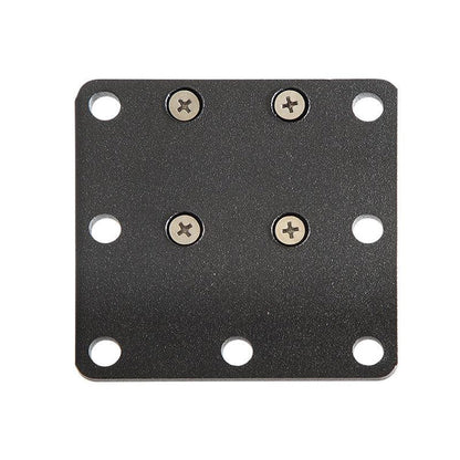 The Square AMPS Mounting Plate is a black, square metal plate with rounded corners, eight holes (four at the corners), and four screws installed in a VESA 75 pattern near the center.