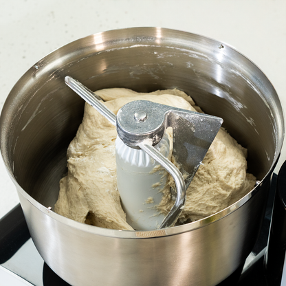 Bosch black stainless steel bowl kneading dough on white counter