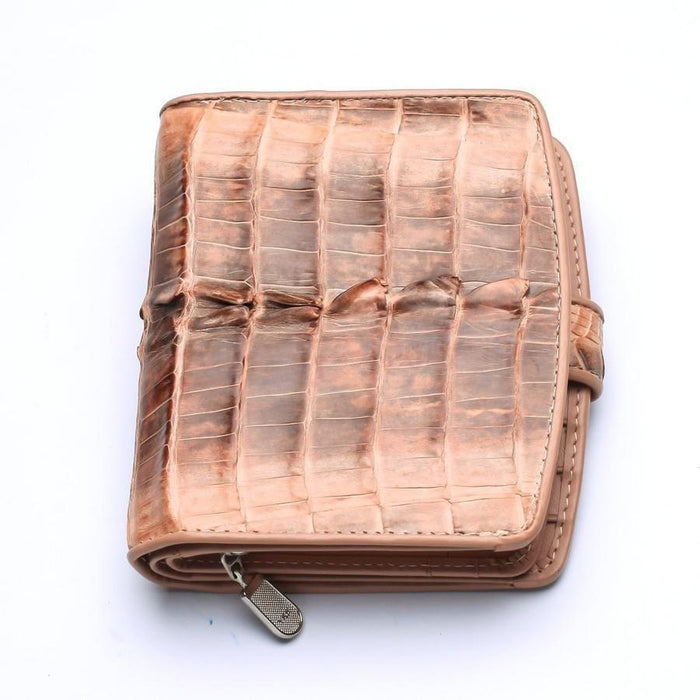 Top-down view of closed old rose crocodile leather wallet showing raised spine scales and silver zipper pull