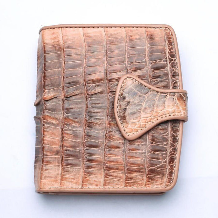 Teardrop-shaped flap closure detail on old rose crocodile leather wallet with visible hand-stitching and two-tone scale texture