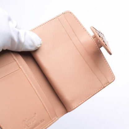 Right interior panel of old rose wallet displaying three smooth peach leather card slots and crocodile-scale flap tab closure