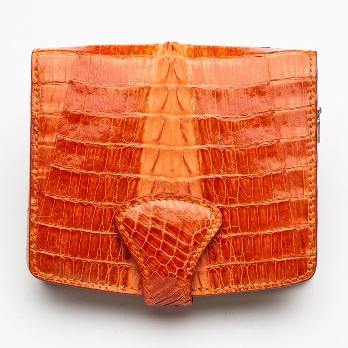 Fully opened exterior spread of the orange crocodile leather wallet displaying natural scale pattern and triangular snap tab closure