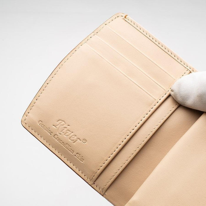 Embossed River Genuine Crocodilian Skin brand stamp on cream leather interior with card slot stitching detail