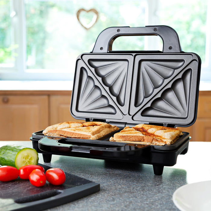 Triangular sandwich maker with two sandwiches being made on a kitchen counter.  - Buy Now Deep Fill Sandwich Toaster