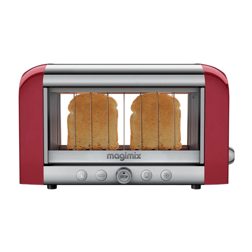 A red Magimix toaster with transparent glass side windows showing toasting bread, featuring stainless steel and borosilicate glass construction with control buttons on the front.